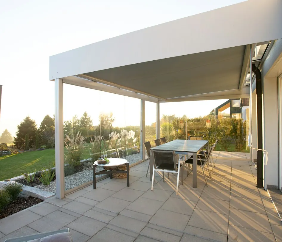 Moderne Terrassenüberdachung mit Esstisch im Abendlicht