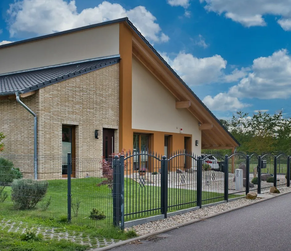 Modernes Wohnhaus mit Metallzaun zur Straße